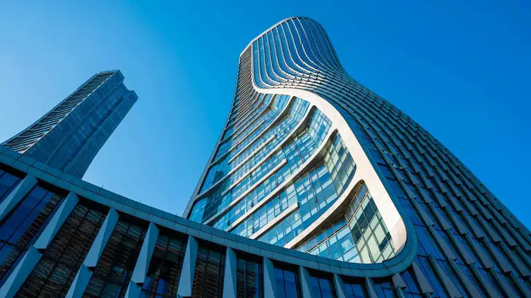 Curved glass tower, a commercial property where attorneys search for liens before closing