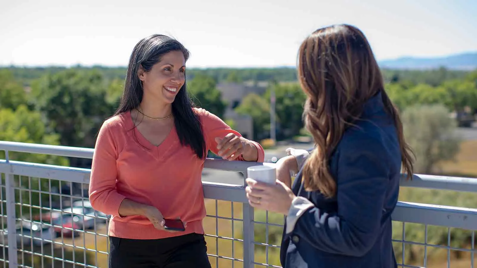 Two professionals comparing pro title services providers on a balcony meeting