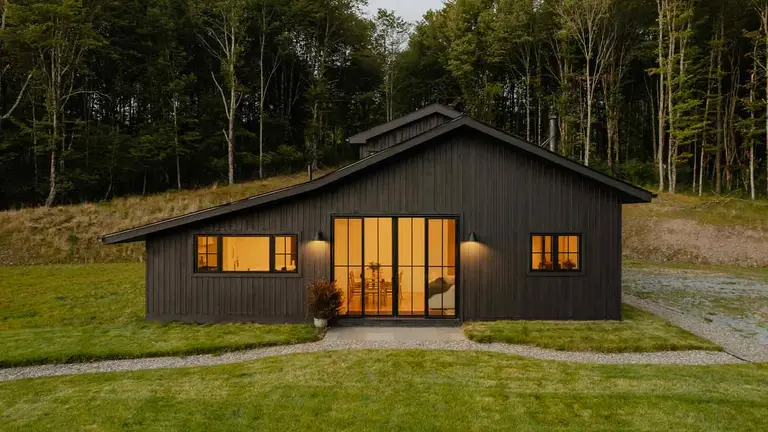 Modern barn-style home at dusk researched through pro title services