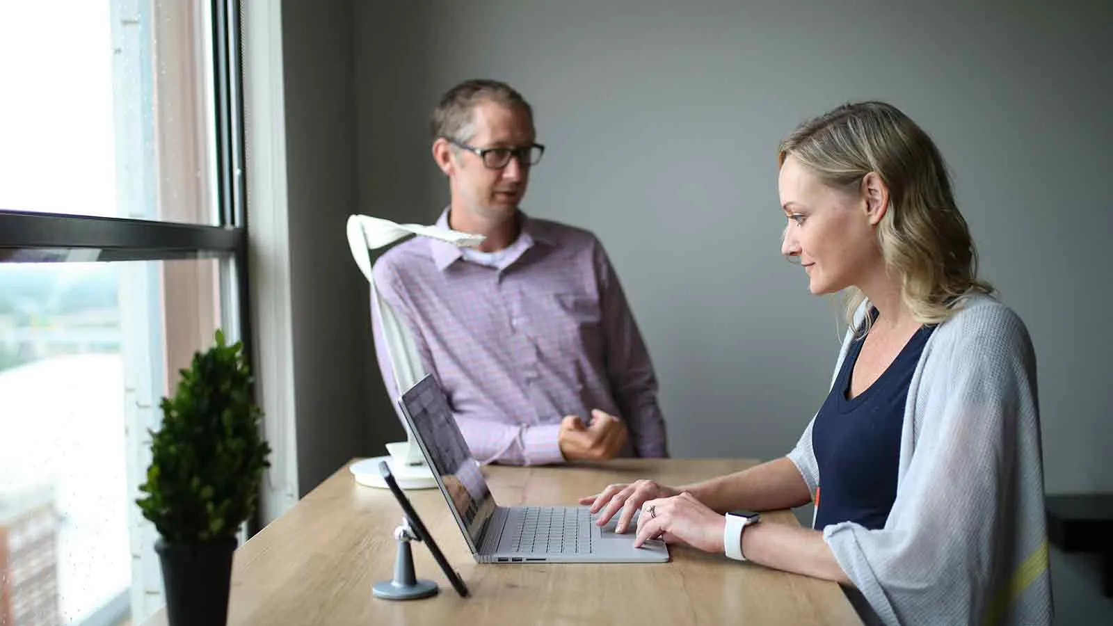Advisor walking a client through address lookup results on a laptop