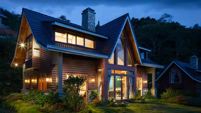 Timber home lit at night, identified through an address lookup of county records