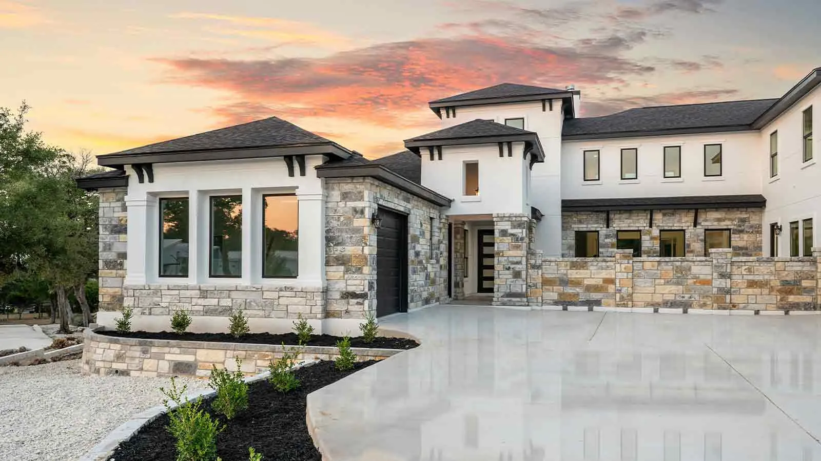 Stone estate home at sunset completed under a construction escrow agreement