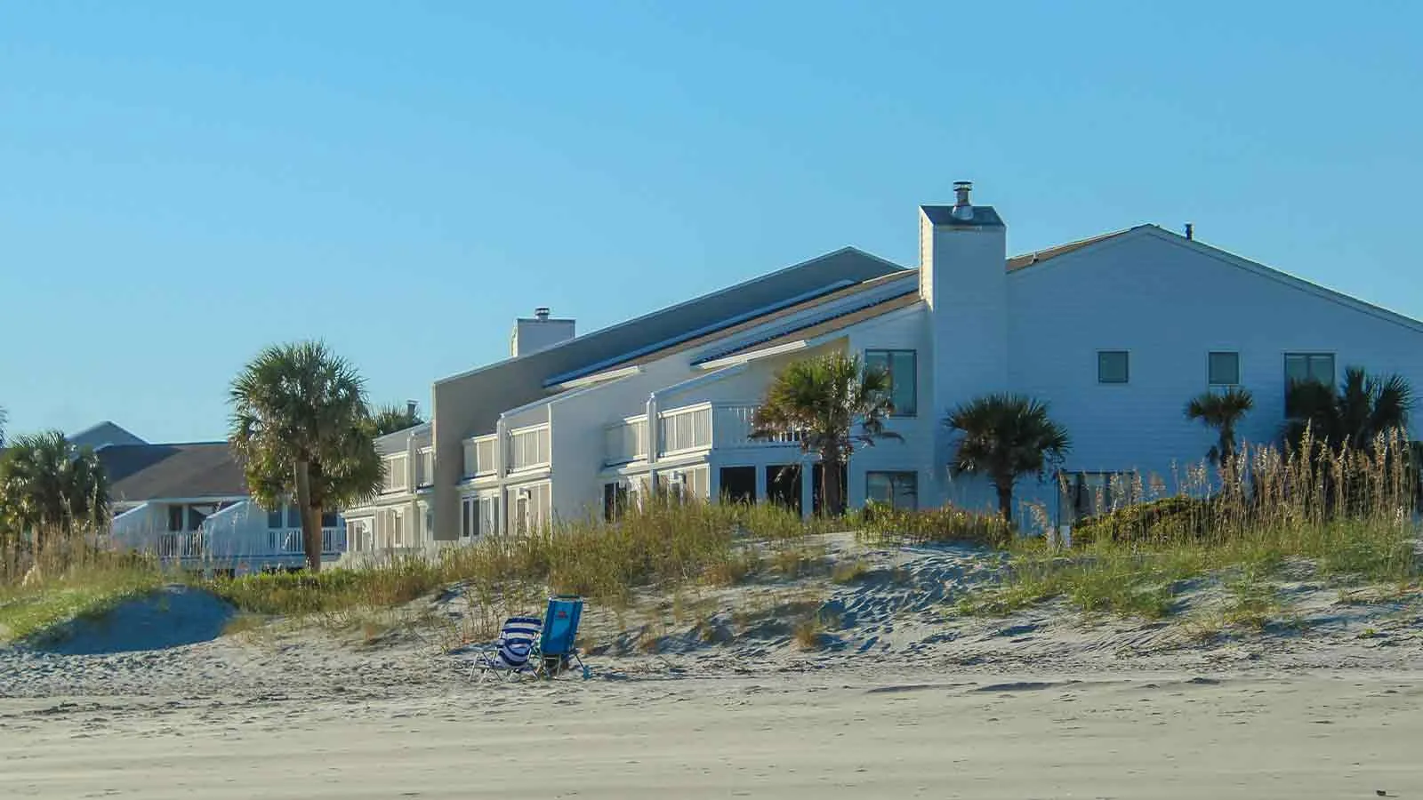 Row of homes along open dunes, properties verified through county land research